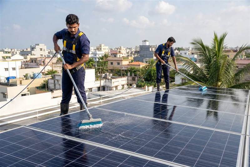 Technicians inspecting rooftop solar panels